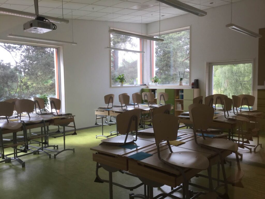 Tomt klassrum med stolar som står på bänkarna