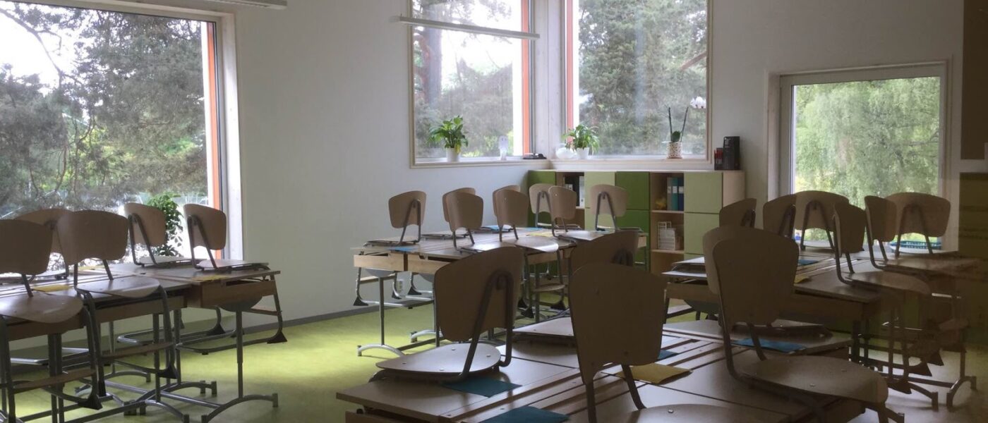 Tomt klassrum med stolar som står på bänkarna