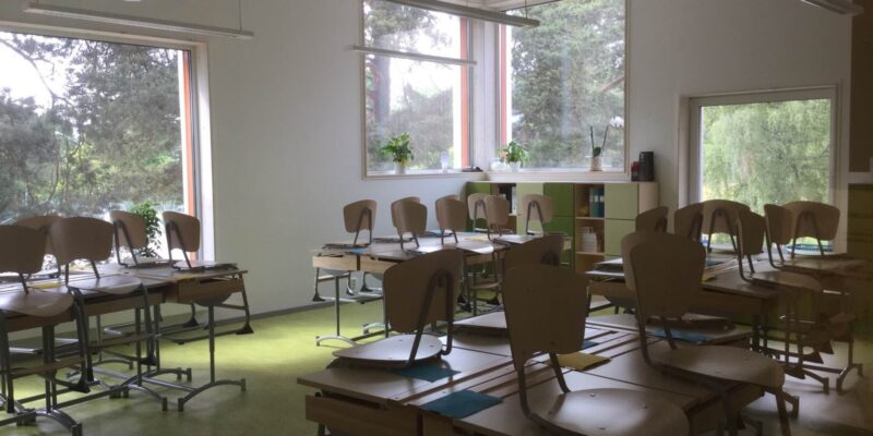 Tomt klassrum med stolar som står på bänkarna